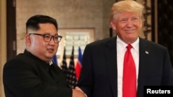 Tổng thống Mỹ Donald Trump và lãnh tụ Triều Tiên Kim Jong Un bắt tay sau khi ký các văn kiện tại cuộc họp thượng đỉnh trên đảo Sentosa, Singapore, ngày 12/6/2018. 