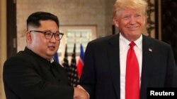 도널드 트럼프 미국 대통령과 김정은 북한 국무위원장이 지난 6월 싱가포르 정상회담에서 악수하고 있다.