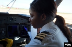 Preparing for departure - assistant pilot Lusekele Mwenefumbo performs checks in the cockpit of the Bombardier Q400 aircraft, at Chileka International Airport in Blantyre, Malawi, March 16, 2017. (L. Masina/VOA)