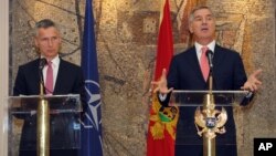 FILE - Montenegro's Prime Minister Milo Djukanovic, right, speaks and gestures after talks with NATO Secretary-General Jens Stoltenberg, in Podgorica, Montenegro.