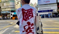 区议员徐子见穿上象征反对港版国安法的衬衫，监察警方6月28日九龙静默游行的执法情况，后来被警方拘捕。 (美国之音/汤惠芸)