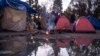 Un niño se calienta en una fogata de un campamento de solicitantes de asilo mexicanos en el Parque Chamizal, cerca del Puente de las Américas en Ciudad Juárez, México, el 13 de diciembre de 2019. 