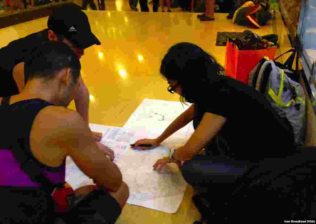 Inside the Admiralty metro station, a main transport hub for the occupation campaign, three teen-aged Occupy Central members pore over a crude map. They make up the evacuation team, responsible for planning an exit strategy for the tens of thousands of protesters who remain on site, should a police offensive cause another stampede, Hong Kong, Oct. 5, 2014. 