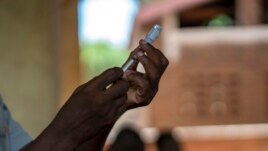 FILE - In this file photo taken Wednesday, Dec. 11, 2019, health officials prepare to vaccine residents of the Malawi village of Tomali, where young children become test subjects for the world's first vaccine against malaria.