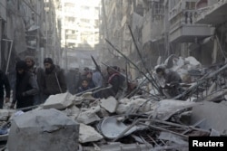 FILE - Residents inspect damage after airstrikes by pro-Syrian government forces in the rebel-held Al-Shaar neighborhood of Aleppo, Syria, Feb. 4, 2016.