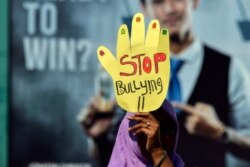 Seorang aktivis mengikuti acara memperingati Hari Perempuan Sedunia di Banda Aceh, Aceh, 8 Maret 2019. Seorang pengunjuk rasa membawa spanduk bertuliskan "Stop Bullying". (Foto: AFP/Chaideer Mahyuddin)