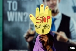 Seorang pengunjuk rasa membawa spanduk bertuliskan "Stop Bullying" dalam peringatan Hari Perempuan Sedunia di Banda Aceh. (Foto dok: AFP/Chaideer Mahyuddin)