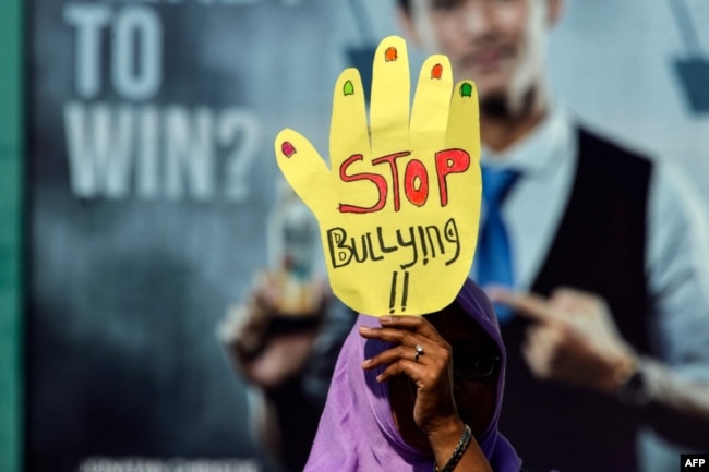 Seorang aktivis mengikuti acara memperingati Hari Perempuan Sedunia di Banda Aceh, Aceh, 8 Maret 2019. Seorang pengunjuk rasa membawa spanduk bertuliskan "Stop Bullying". (Foto: AFP/Chaideer Mahyuddin)