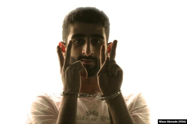 Mohammed-Noor Mattar, 22, a media activist from Raqqa showing a victory sign while handcuffed during a campaign against oppression. After he was kidnapped by the Islamic State in 2013, his family never heard anything of his fate.