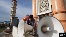FILE – A worker inspects a loudspeaker at a mosque in Aceh province, Indonesia, June 28, 2014.