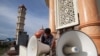 FILE – A worker inspects a loudspeaker at a mosque in Aceh province, Indonesia, June 28, 2014.