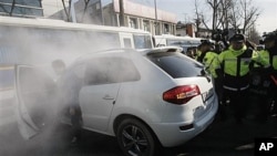 South Korean protester rams car into police bus guarding Chinese Embassy during rally to denounce Chinese fisherman, Seoul, Dec. 13, 2011.