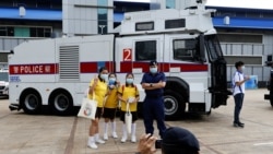 在“全民國家安全教育日“展覽當中，小學生在警察水炮車旁邊拍照（路透社照片）