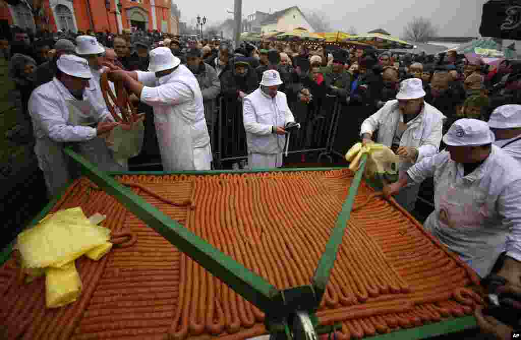 Para koki menjual sosis sepanjang 2.031 yang dibuat untuk Festival Sosis ke-31 di desa Turija, sekitar 100 kilometer Belgrade barat laut, Serbia, 28 Februari 2015.