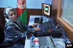 FILE - A female Afghan journalist is seen working at a radio station in Herat, Afghanistan, Oct. 14, 2012. The rising insecurity in Afghanistan has reportedly led to a decrease in the number of female journalists working and reporting on women's issues in the country.