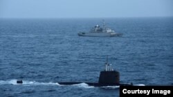 法国国防部长在推特上公布的照片显示法国核潜艇在一艘军舰支持下在南中国海巡逻。