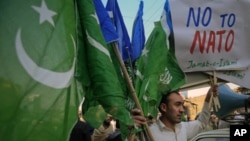 A supporter of Jamaat-e-Islami, a religious and political party, holds collected party flags and placards after an anti-American demonstration in Peshawar, December 2, 2011.