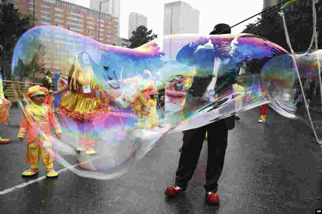 지난 9일(현지시간) 콜롬비아 보고타에서 진행된 반정부 시위에서 광대 분장을 한 시민이 거대한 비누방울을 만들고 있다.