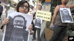 Pro-democracy protesters carry portraits of detained Chinese artist Ai Weiwei in Hong Kong, April 10, 2011