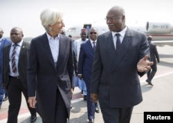 IMF Managing Director Christine Lagarde is greeted by Cameroon's Prime Minister Philemon Yang, right, upon arriving at the Yaounde airport, Jan. 7, 2016.