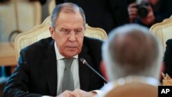 FILE - Russian Foreign Minister Sergey Lavrov listens to U.S. Secretary of State Rex Tillerson, right back to the camera, during their talks in Moscow, Russia, April 12, 2017.