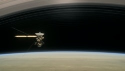 This image made available by NASA in April 2017 shows a still from the short film "Cassini's Grand Finale," with the spacecraft diving between Saturn and the planet's innermost ring. (NASA/JPL-Caltech via AP)