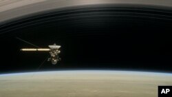 This image made available by NASA in April 2017 shows a still from the short film "Cassini's Grand Finale," with the spacecraft diving between Saturn and the planet's innermost ring. (NASA/JPL-Caltech via AP)