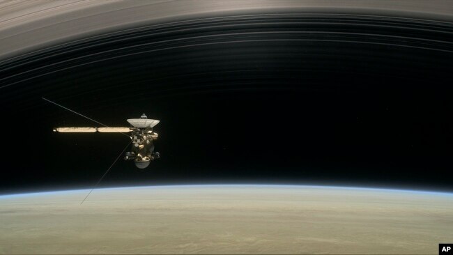 This image made available by NASA in April 2017 shows a still from the short film "Cassini's Grand Finale," with the spacecraft diving between Saturn and the planet's innermost ring. (NASA/JPL-Caltech via AP)