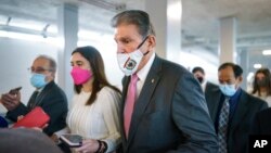 Sen. Joe Manchin, D-W.Va., a key holdout vote on President Joe Biden's domestic agenda, is surrounded by reporters at the Capitol in Washington, Nov. 2, 2021. 