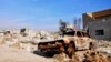 A burned out car lies amid damaged buildings in Ramadi, 70 miles (115 kilometers) west of Baghdad, Iraq, on Jan. 2, 2016. Iraq's military says Islamic State militants launched attacks Friday with seven suicide car bombs.