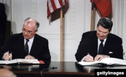 Aralık 1987'de Orta Menzilli Kuvvetler Anlaşması'nı imzalayan dönemin Sovyet ve ABD liderleri, Mikhail Gorbaçov ve Ronald Reagan. Anlaşma iki ülkenin orta menzilli füze konuşlandırmasını yasaklıyordu.