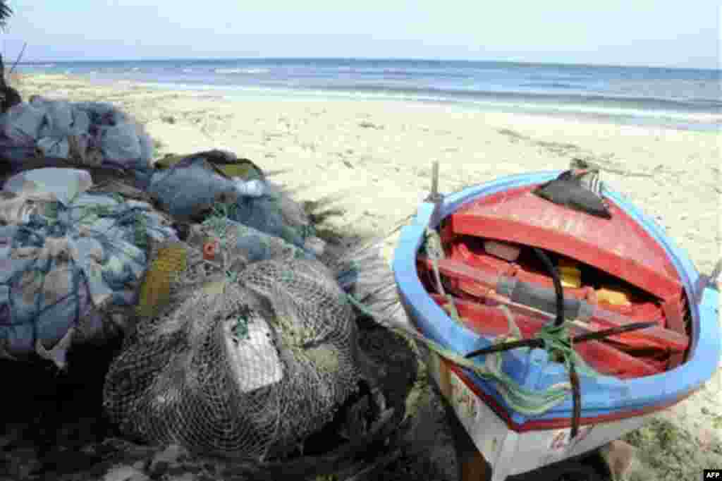 A fisherman's boat is seen on a beach at Sounine, Tunisia, Tuesday Feb. 15, 2011. The village is one of the departing site for would-be immigrants from North Africa toward Italy's shores, despite hours of sailing. More than 4,000 migrants have landed on t