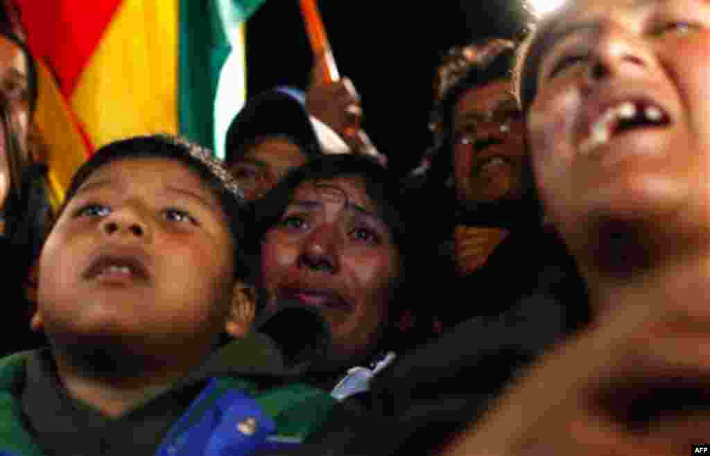 Relatives of trapped Bolivian miner Carlos Mamani Solis react while watching his rescue on a TV screen at the camp outside the San Jose mine near Copiapo, Chile, early Wednesday, Oct. 13, 2010. (AP Photo/Natacha Pisarenko)