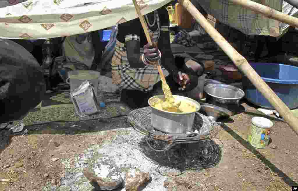 A displaced woman stirs fortified cereal mix at the U.N. compound where she has sought shelter in Juba, Dec. 23, 2013.