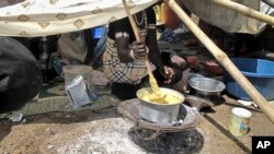 A displaced woman stirs fortified cereal mix at the U.N. compound where she has sought shelter in Juba, Dec. 23, 2013.