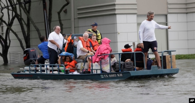 Residents are evacuated from their homes surrounded by floodwaters from Tropical Storm Harvey Sunday, Aug. 27, 2017, in Houston, Texas.