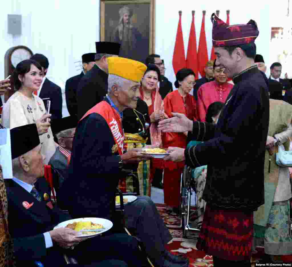 Presiden Joko Widodo memberikan salah satu potongan tumpeng pertama kepada pahlawan dan veteran perang kemerdekaan, Jakarta, 17 Agustus 2017. (Courtesy: Setpres RI)