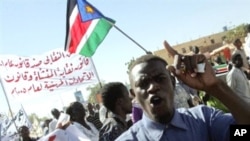 A Sudanese opposition supporter shouts slogans as protesters wave the flag of Sudan People's Liberation Movement (SPLM) during a demonstration against the government in Khartoum, 07 Dec 2009