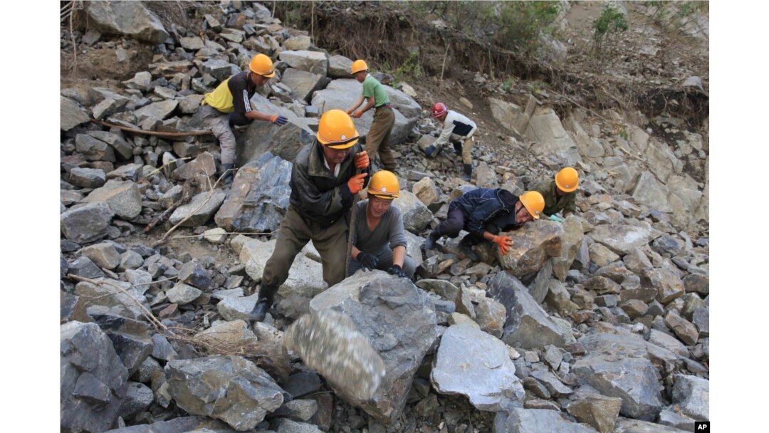FILE - Workers repair the flood-damaged train track between Sinjon and Kanphyong train stations, North Hamgyong Province, North Korea, Sept. 16, 2016. Amid recent nuclear tensions, Pyongyang is struggling to secure aid for victims of flooding that occurred earlier this month.