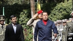 Venezuelan President Hugo Chavez, center left, reviews an honor guard, as he is accompanied by his Iranian counterpart Mahmoud Ahmadinejad, left, during an official welcoming ceremony, in Tehran, Iran, 19 Oct. 2010