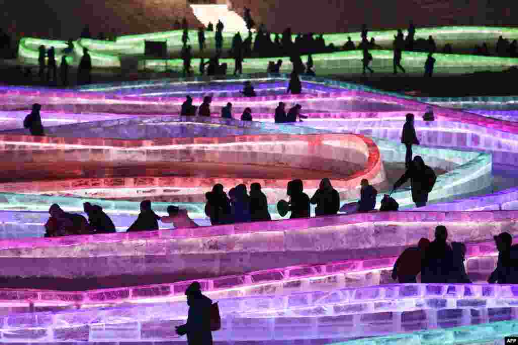 Visitors walk and slide on icy paths on the opening day of the annual Harbin Ice and Snow Sculpture Festival in Harbin, in China&#39;s northeast Heilongjiang province.