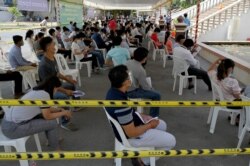 Pejabat dari Kementerian Penerangan menunggu disuntik vaksin COVID-19 Sinovac di Kementerian Penerangan, Phnom Penh,1 April 2021. (Foto: TANG CHHIN Sothy / AFP)