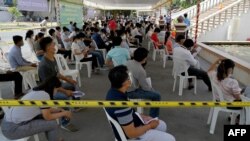 Officials from the Ministry of Information wait to receive China's Sinovac Covid-19 coronavirus vaccine at the Ministry of Information in Phnom Penh on April 1, 2021. (Photo by TANG CHHIN Sothy / AFP) 