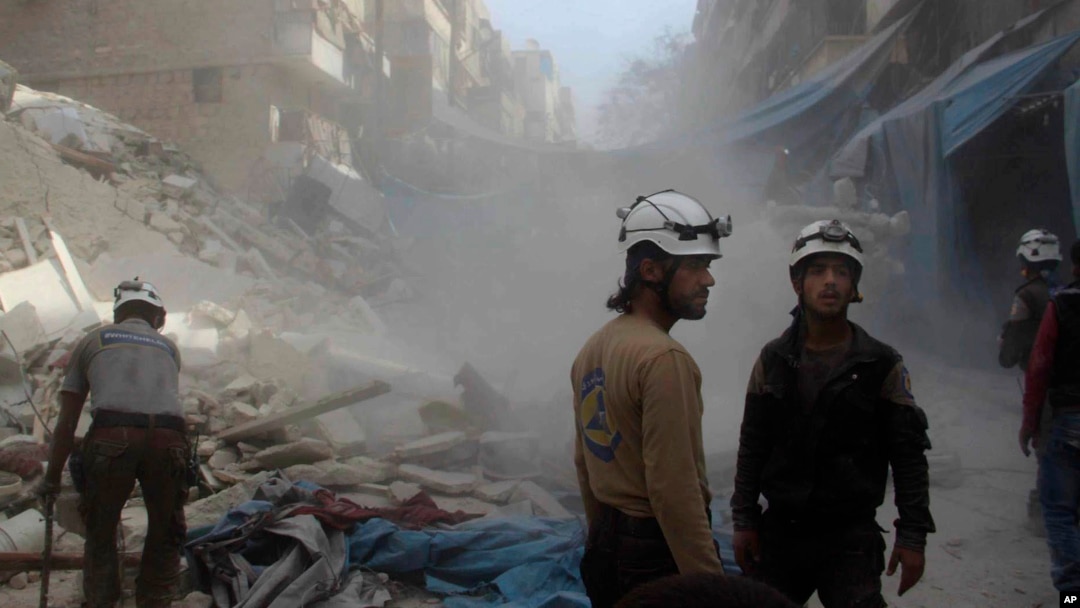 In this picture provided by the Syrian Civil Defense group known as the White Helmets, Syrian Civil Defense workers search through the rubble in rebel-held eastern Aleppo, Syria, Oct. 12, 2016.