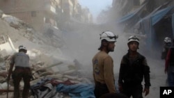 In this picture provided by the Syrian Civil Defense group known as the White Helmets, Syrian Civil Defense workers search through the rubble in rebel-held eastern Aleppo, Syria, Oct. 12, 2016.