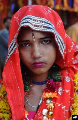 FILE - Child bride Laxmi, 14, looks on at the Balaji temple in Kamkheda village, in the western Indian state of Rajasthan, May 7, 2011.