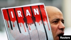 An Iranian exile shouts slogans to protest against executions in Iran during a demonstration in front of the Iranian embassy in Brussels December 29, 2010.