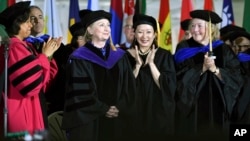 Faculty members cheer former Secretary of State Hillary Clinton after she delivered the commencement address at Wellesley College, May 26, 2017 in Wellesley, Mass. Clinton graduated from the school in 1969.