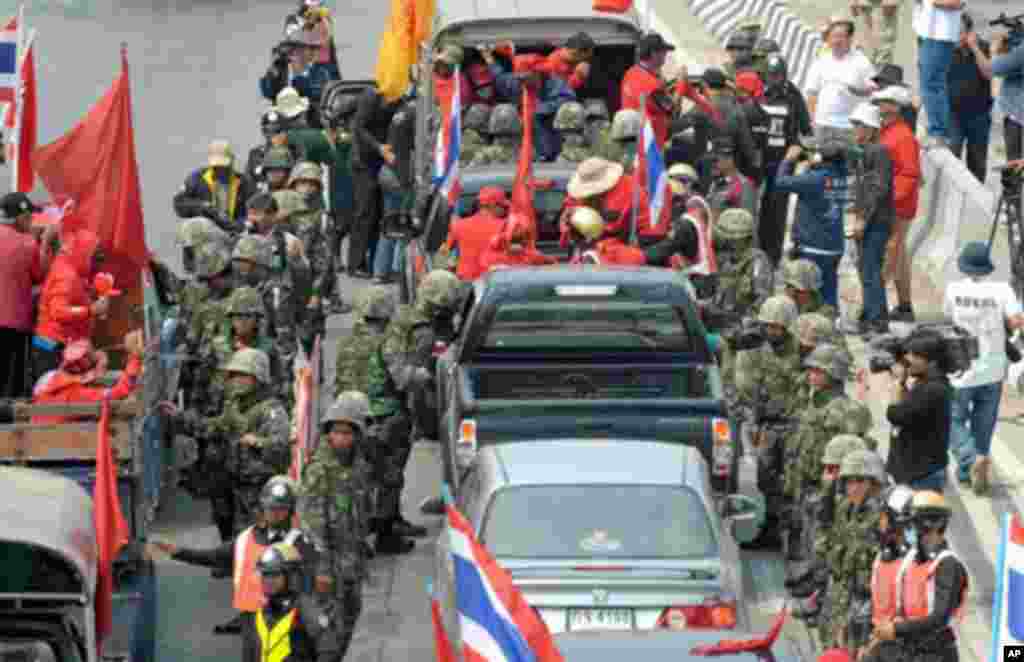 Thai soldiers and policemen check security on a convoy of supporters of deposed Thai premier Thaksin Shinawatra as they head to Bangkok for a mass anti-government rally, at check-point in Ayutthaya province on March 13, 2010.