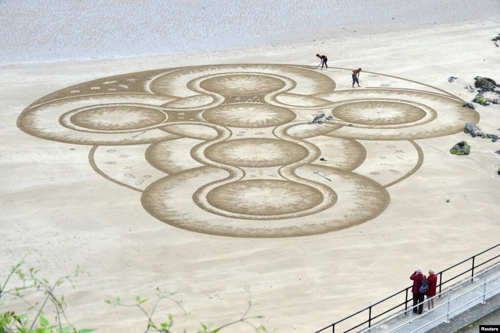 영국 웨일스의 텐비하버 인근에서 모래 예술가 마크 트레노가 작품을 만들고 있다.